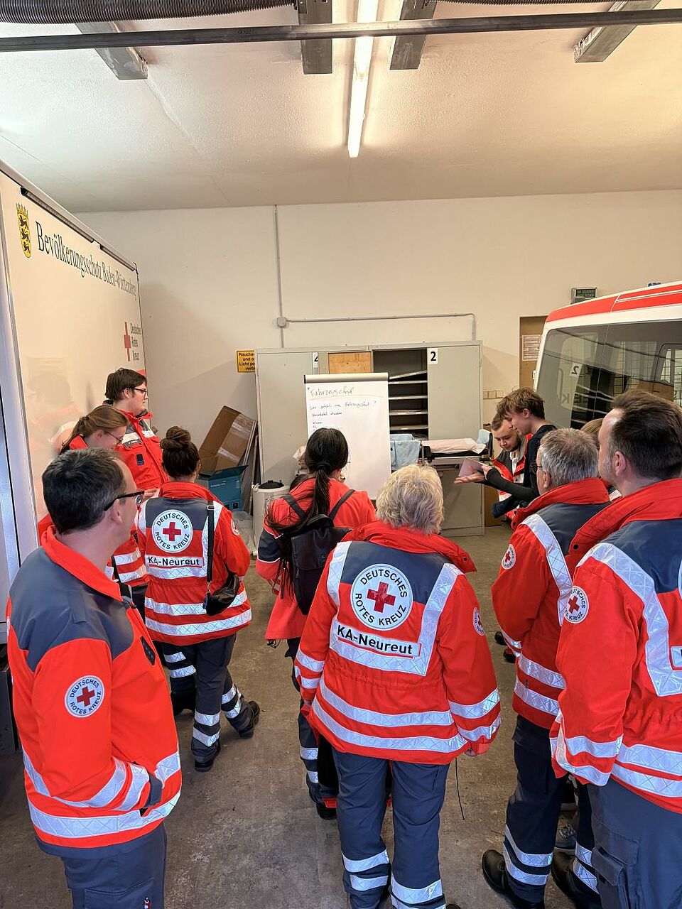 Vor dem Losfahren muss der Fahrzeugcheck und die Überprüfung der Beladung durchgeführt werden. In der Fahrzeughalle treffen sich die aktiven Rotkreuzler zum Fahrzeugcheck